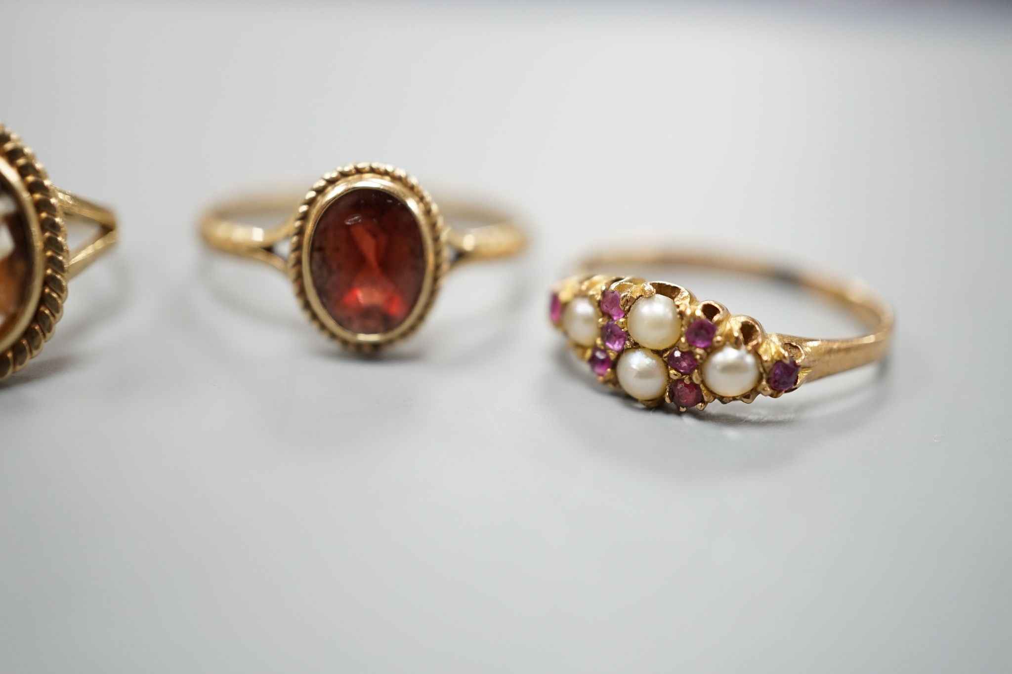 A late Victorian 15ct gold, seed pearl and amethyst cluster set ring, size L, gross 2.1 grams and two later 9ct gold rings including cameo shell, gross 3.2 grams.